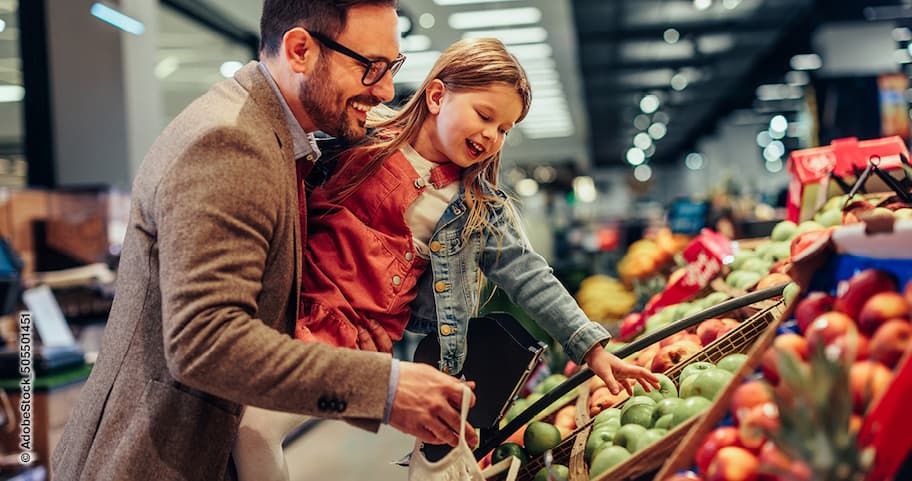 Vater und Tochter im Supermarkt beim Auswählen von Früchten